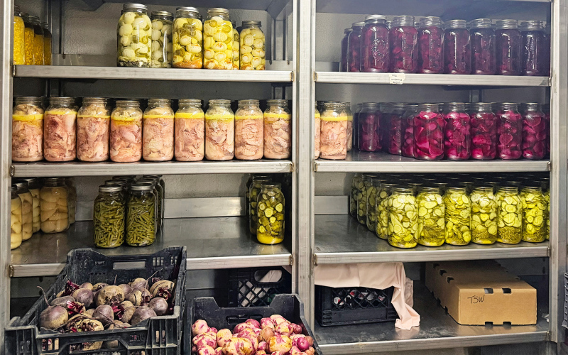 Pickled and preserved vegetables in a storage room at Spring Valley Colony, pictured July 17, 2026. (PHOTO: ELENA TITTEL/SD NEWS WATCH)