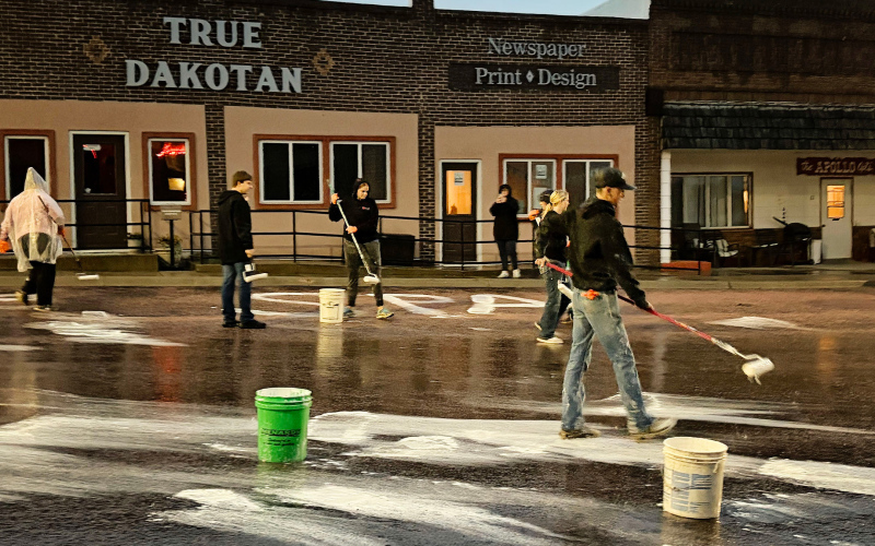 WSHS seniors brave the rain Sunday evening to continue the generations-old tradition of whitewashing streets to kick off Homecoming week. By Monday, the rain had washed away virtually every trace of their work.(PHOTO COURTESY SARA THOMPSON)