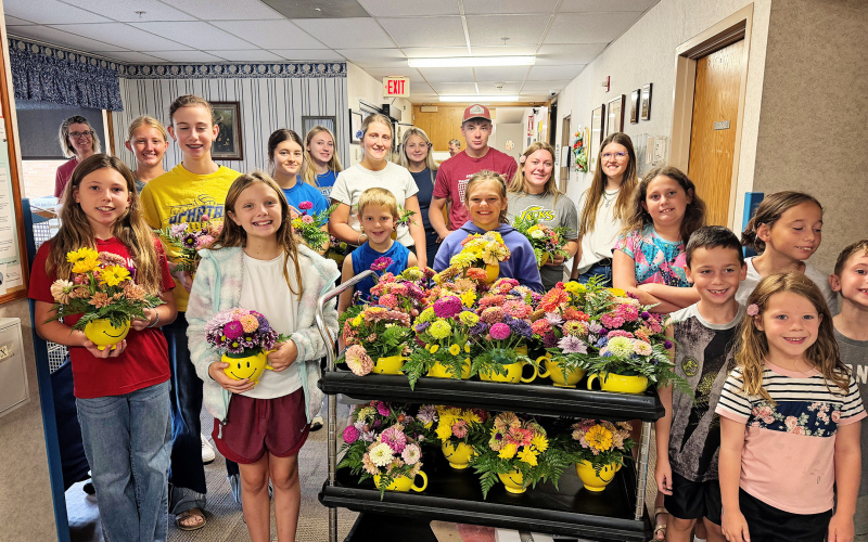 Mercedes Jones helps Jerauld-Buffalo County 4-H members arrange flowers for their annual Light-A-Smile project. Jones guided the youth through the bouquet-making process, helping them create colorful arrangements to brighten the days of Weskota Manor Avera nursing home residents. Jerauld-Buffalo County 4-H members show off the colorful floral arrangements they created for Weskota Manor Avera nursing home residents as part of their annual Light-A-Smile community service project.
