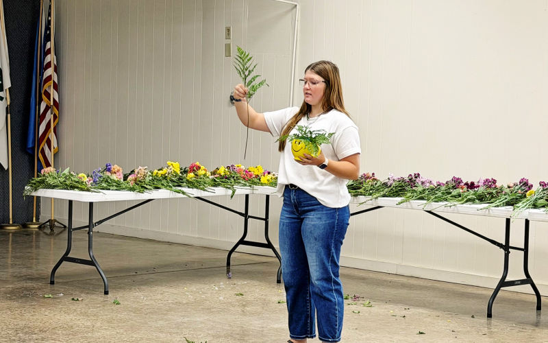 Mercedes Jones helps Jerauld-Buffalo County 4-H members arrange flowers for their annual Light-A-Smile project. Jones guided the youth through the bouquet-making process, helping them create colorful arrangements to brighten the days of Weskota Manor Avera nursing home residents.