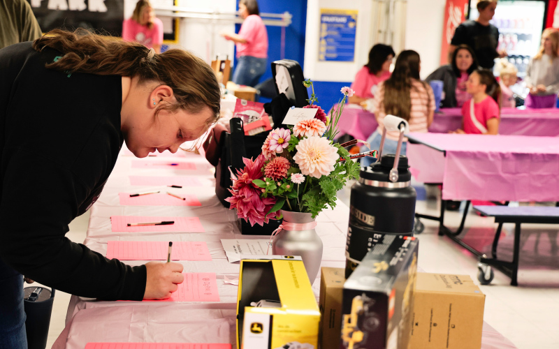 Anna Arhart places a bid during a competitive silent auction.