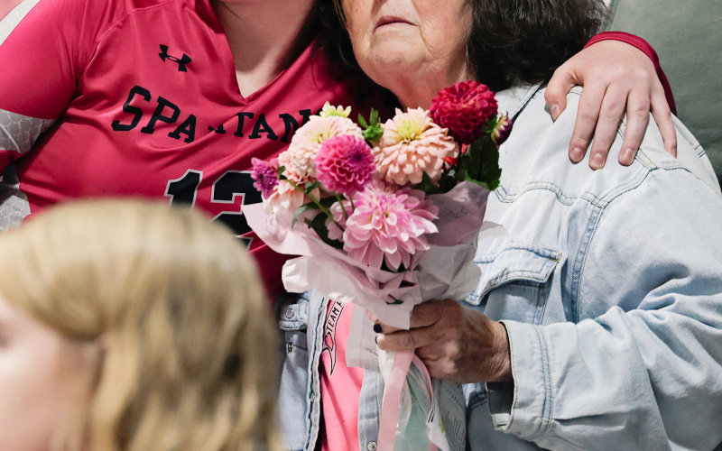 During an emotional flower ceremony honoring those affected by cancer, Brooklyn Caffee presents flowers to her grandmother, Fran Peterson.
