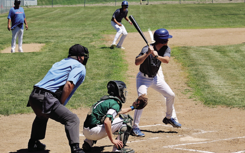 TOP: Dylan Schimke bats with Brock Krueger at third base during Sunday’s doubleheader against Chamberlain. Schimke drove in five runs across the two games as the Owls swept the Mallards. ABOVE: Springs Owl pitcher Bubba Peterson delivers a pitch during a first game doubleheader in Springs on Sunday. Despite 96 degree temperatures, Peterson pitched a six-inning 12-1 victory over the Chamberlain Mallards, striking out ten batters. (PHOTOS BY CRAIG WENZEL FOR THE TRUE DAKOTAN)