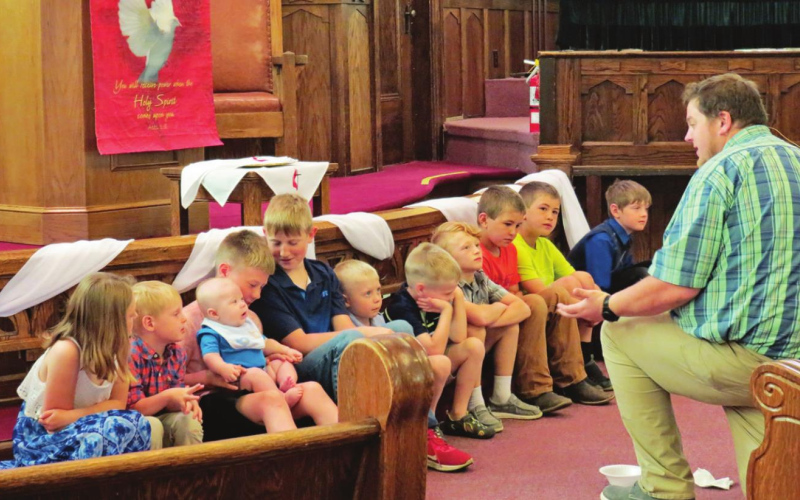 Connecting with children and young adults is seen as an important way to grow church membership in the future. Here, Methodist Pastor Zach Kingery teaches scripture to children at the United Methodist Church of Wessington Springs during a “Young Disciples Moment” in 2022. Photo: Courtesy Laura Kieser, UMC