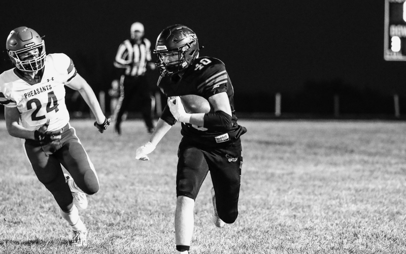 KRISTI HINE / TRUE DAKOTAN TOP: Hands over hearts, the Blackhawks salute the flag during the National Anthem. CENTER: Brady Larson on the run. ABOVE: Camden Jost navigates his way down the field.