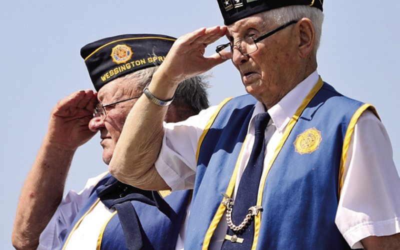 Legion members Jerry Fastnacht and Dareld Bucholz salute the flag during the Prospect Hill Memorial Day Program in Wessington Springs.