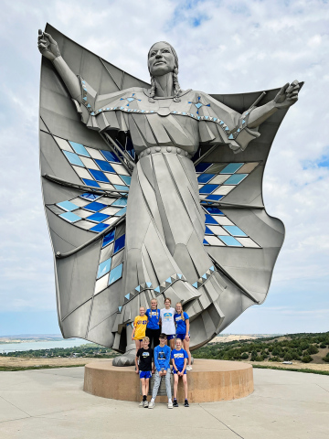 The cross country Spartans in Chamberlain with the “Dignity” sculpture.