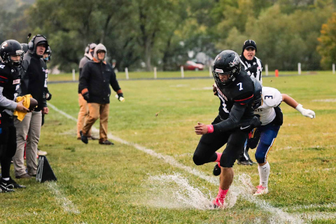 Holden Havlik runs the football out of bounds, evading a tackle but landing ankle deep in a puddle. Soggy field conditions made moving the football a task for both the Blackhawks and Rapid City Christian.