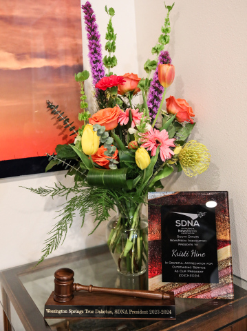 South Dakota NewsMedia Association (SDNA) plaque, honorary gavel and flowers presented to Kristi Hine by SDNA board and staff for work done during the 2023-24 year as SDNA President.
