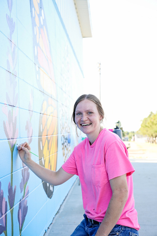 KRISTI HINE / TRUE DAKOTAN Local artist and SACOTA intern Ruthe Lindvall puts final touches on the new mural located on the east side of the Wessington Springs Pool House. Community members are invited to attend SACOTA’s official mural unveiling, set for July 4 at 12:30 p.m.