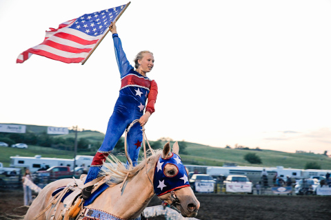 Crazy Cowgirl Trick Rider Candice Aamot proudly displays Old Glory as part of her routine at the Foothills Rodeo Friday evening, July 5. 