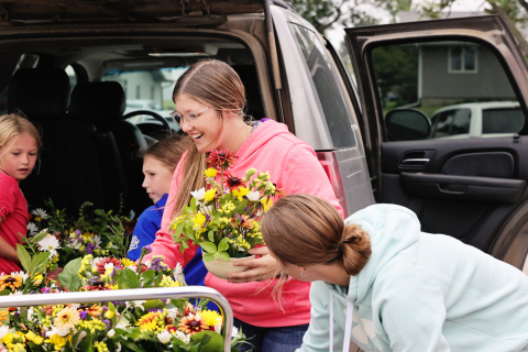 Mercedes Jones and fellow 4-Hers unload bouquets they made for nursing home residents at Weskota Manor Avera. PHOTO COURTESY KATIE JONES PHOTOGRAPHY 