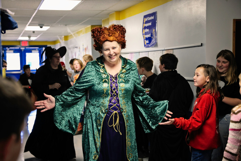 Special Education teacher Terri Moross high fives students as she passes by. 