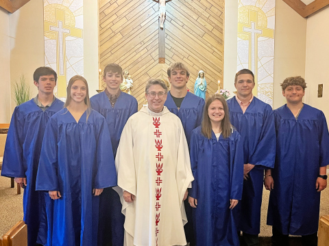 Graduates donned their gowns for a celebration honoring the seniors at St. Joseph Catholic Church. Shown left to right are: Karter Mebius, Bailey Yost, Landen Christensen, Fr. Larry Regynski, Holden Havlik, Kennedy Kolousek, Robert Hine, Will Bruckner.