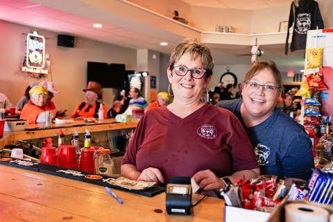 Marci Schimke and Deb Fastnacht served thirsty poker run attendees inside, while Madeline Gran served customers outdoors. T