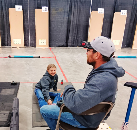 With her Dad and coach Jared spotting with his binoculars, Crawleigh Reiner smiles after a personal best in BB Gun at the State 4-H Shoot in Ft. Pierre, SD. COURTESY PHOTO