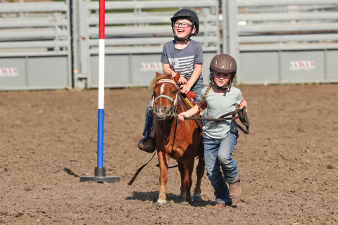 Kimber Shryock leads brother Colt through a pattern during the August 11, 2025 Foothills PlayDays. The youth, in Wessington Springs visiting grandparents Craig and Kelli, were among hundreds of children from across the region to participate in the event. KRISTI HINE / TRUE DAKOTAN