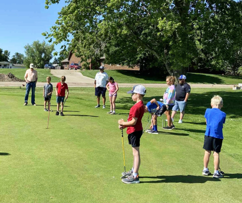 Young golfers focus on their form during the youth golf clinics at Springs Country Club, where volunteers helped participants practice putting, chipping, and fairway play while learning golf etiquette and sportsmanship.
