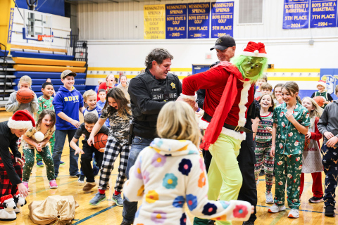 The Grinch is led from the Wessington Springs Elementary School gymnasium by Jerauld County Sheriff Jason Weber and Deputy Mike Krueger on Friday, Dec. 19, as students erupt in cheers following his apprehension. (KRISTI HINE / TRUE DAKOTAN)