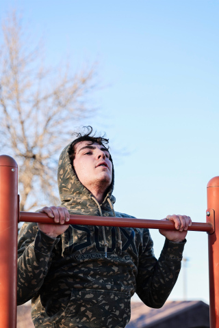 Ethan Rearick powers through pull-ups at the city park during an outdoor workout session as the Warhawks fine-tune their conditioning. 
