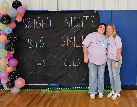 Wessington Springs High School students Tierney Knipfer and Kendall Kolousek smile during Bright Nights, Big Smiles, a glow-themed family engagement event they organized at the Wessington Springs Rec Center.