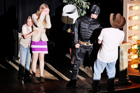 Lily Roesler (playing Nancy Drew) peeks through her hands as Paisley Kapp (as Joe Hardy) clutches her in fear as they witness an altercation between Holden Jackson (playing Batman) and Frank Hardy (as played by Zandon Beyer). 