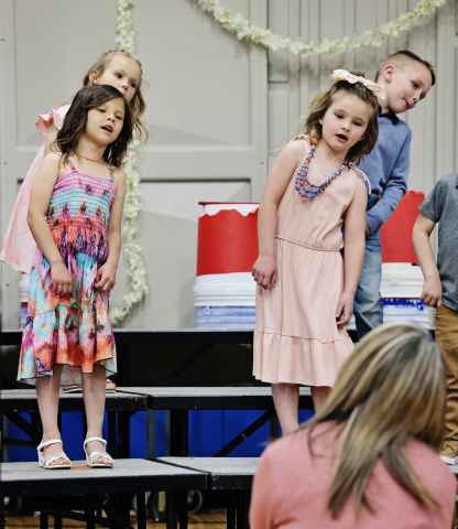 Director Julie Fastnacht leads the preschool class in a performance of “Humpty Dumpty” during the Wessington Springs Elementary Spring Concert May 4, 2026. Moxee Mitchell and Hailey Hasty are pictured on stage. (KRISTI HINE / TRUE DAKOTAN)