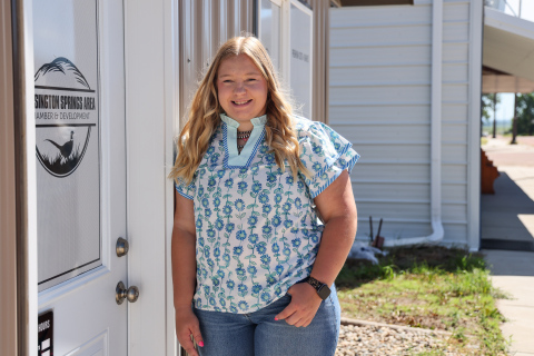 Lilli Steeke, executive secretary and community liaison for the Wessington Springs Area Chamber and Development Corporation, stands outside the organization's Main Street office. Steeke began her role May 11 and supports the WSACD board through event planning, communications, social media and community outreach. (KRISTI HINE / TRUE DAKOTAN)