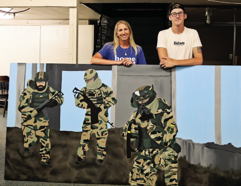 Wessington Springs High School Art Instructor Alicia Roesler stands with WSHS 2023 graduate Jack Neely at the Jerauld County Pioneer Museum’s new building. Neely finished the mural shown above as part of his senior project. The painting will be displayed in the museum’s military room.