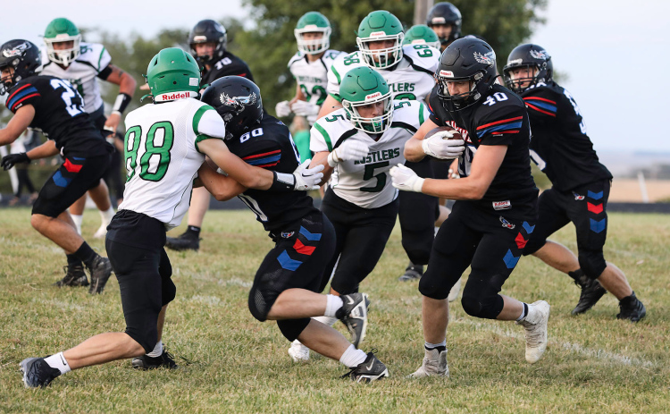 Carter Gaikowski (60) creates a path for Camden Jost to carry the ball down the field. Jost ran for 79 yards in the game.