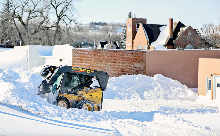 Michial Brodkorb scoops out behind the Springs Area Bus barn and True Dakotan building.
