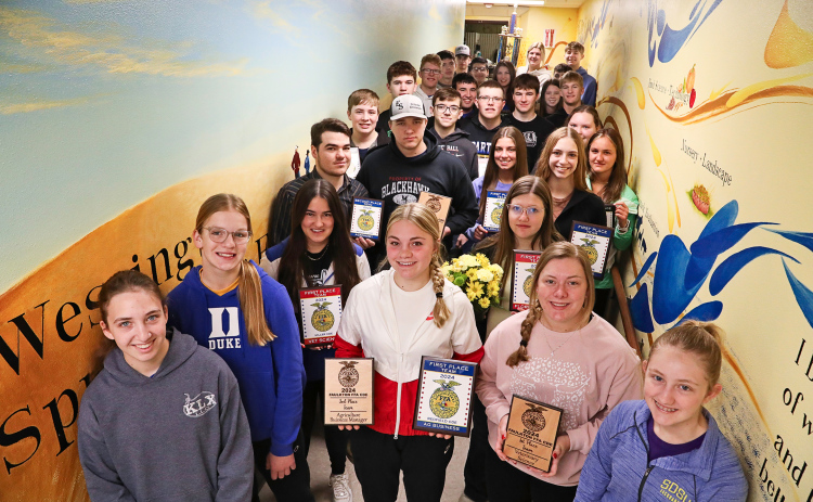 Gathered with their fellow Wessington Springs FFA Chapter members, state-bound students display recent awards they’ve earned at area Career Development Events (CDEs). They are shown in the celebrated mural-lined FFA hallway leading to the vo-ag shop at Wessington Springs High School (WSHS). The mural, painted by WSHS alumna and former FFA member Kenzee Schafer, depicts the rich history of the local chapter’s FFA program. 