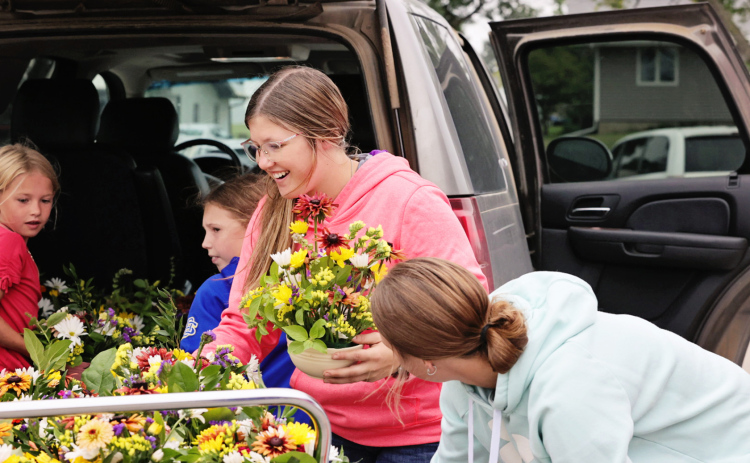 Mercedes Jones and fellow 4-Hers unload bouquets they made for nursing home residents at Weskota Manor Avera. PHOTO COURTESY KATIE JONES PHOTOGRAPHY