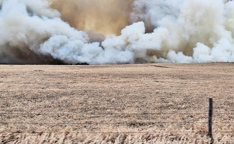 PHOTO COURTESY HELEN HUISMAN Smoke from the weekend wildfire makes its way toward the home of Rod and Helen Huisman. Eight area fire departments were able to contain the blaze, preventing any major damage to structures in the area.