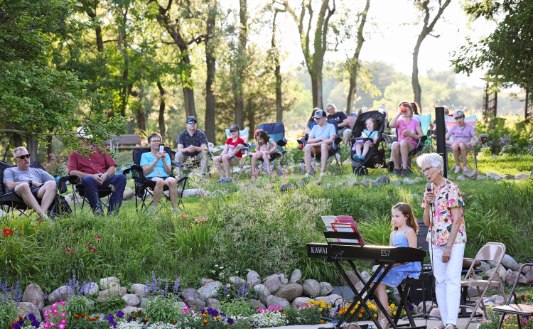 Lois Feistner introduces one of the performers, Emmie Bartel during the July 24, 2025 Music in the Garden.