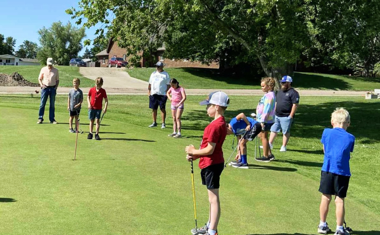 Young golfers focus on their form during the youth golf clinics at Springs Country Club, where volunteers helped participants practice putting, chipping, and fairway play while learning golf etiquette and sportsmanship.