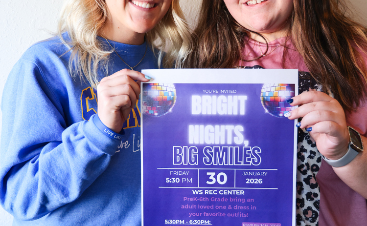 Wessington Springs High School students Kendall Kolousek, left, and Tierney Knipfer hold a flyer for Bright Nights, Big Smiles, a family engagement event they are organizing through the school’s FCCLA chapter. The glow-themed event will be held Jan. 30 at the WS Rec Center. (KRISTI HINE / TRUE DAKOTAN)