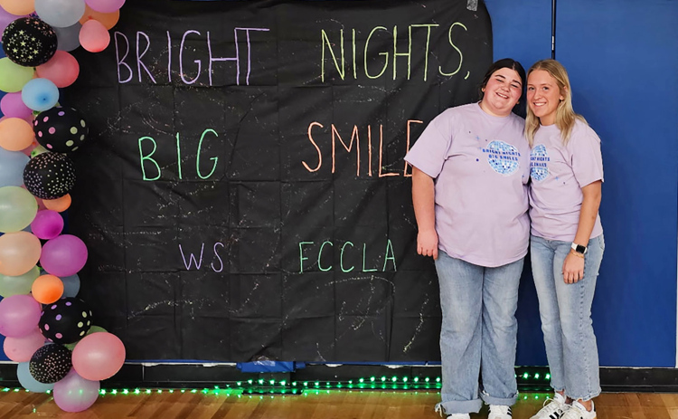 Wessington Springs High School students Tierney Knipfer and Kendall Kolousek smile during Bright Nights, Big Smiles, a glow-themed family engagement event they organized at the Wessington Springs Rec Center.