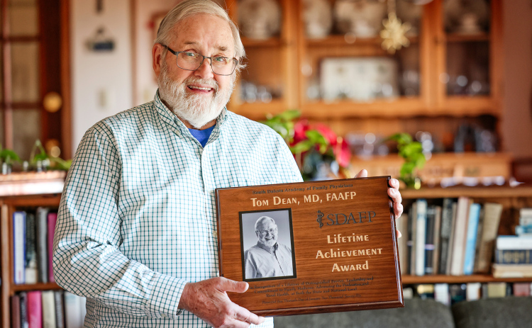 Dr. Tom Dean holds the Lifetime Achievement Award he recently received from the South Dakota Academy of Family Physicians at his home in Wessington Springs. The award recognizes his decades of service to family medicine, rural health and health policy.