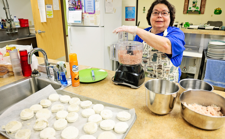 Marla Ness prepares food at the Wessington Springs Senior Community Center, where reduced services and funding challenges have impacted both meal offerings and staff hours. (KRISTI HINE / TRUE DAKOTAN)