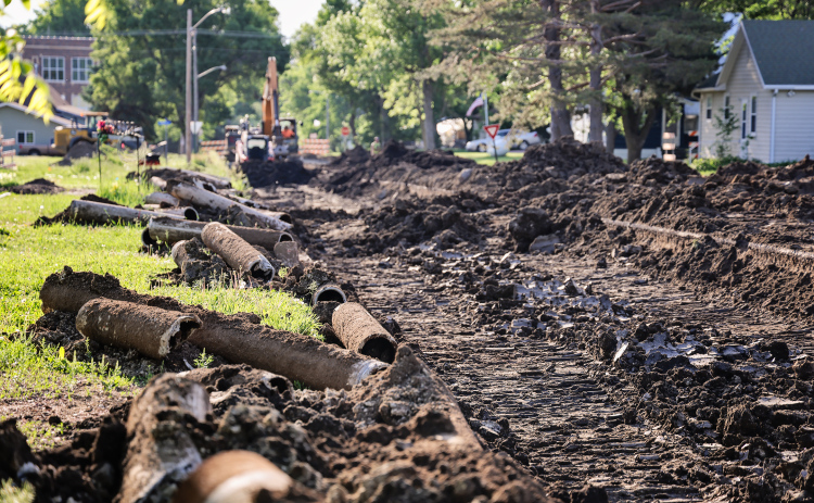 Old cast iron water mains removed from beneath 2nd Street sit alongside an active construction zone as crews continue work on Wessington Springs' water main replacement project. (KRISTI HINE / TRUE DAKOTAN)