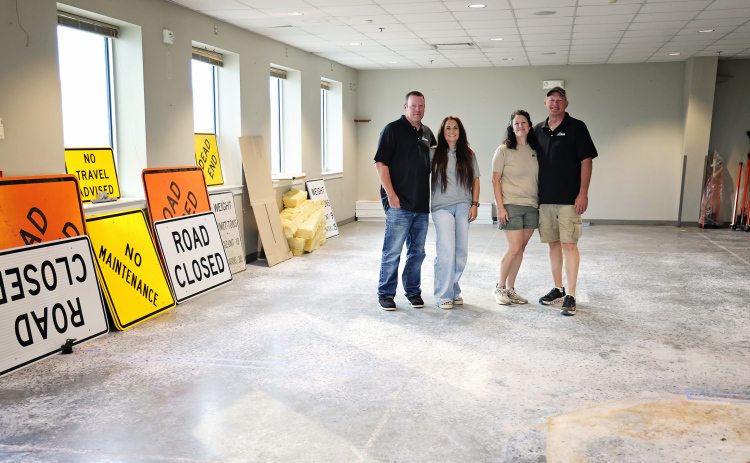 From left, Michael and Jen Feistner and Jennifer and Brian Feistner stand inside the former American Legion building, which the family recently purchased for Feistner Excavation and Gravel. Road closed and no maintenance signs are among the first job materials moved into the building, where work has begun on a large overhead door on the north side for storage access. Construction of office space is planned for this fall. (KRISTI HINE / TRUE DAKOTAN)