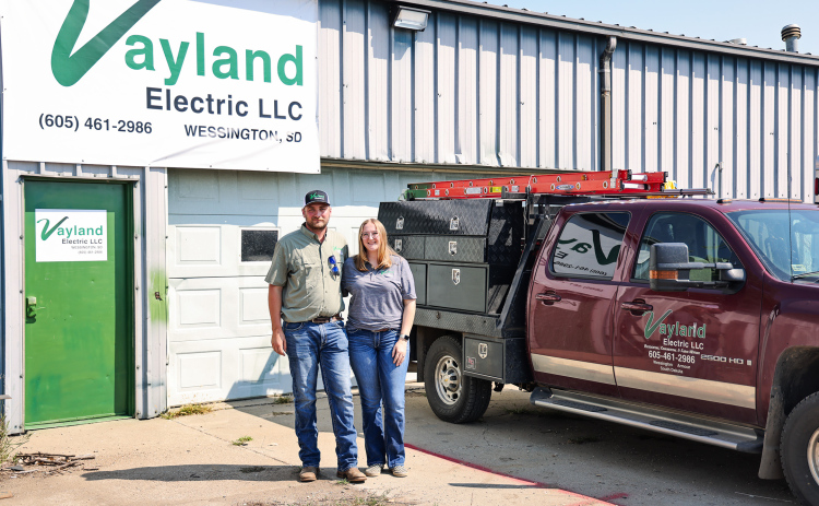 Logan and Josie Schiltz stand outside the Vayland Electric shop near Wessington, where Logan launched his electrical contracting business in January. The shop once housed his grandfather’s Schiltz Manufacturing operation, adding a new chapter to the family property’s entrepreneurial history. (KRISTI HINE / TRUE DAKOTAN)