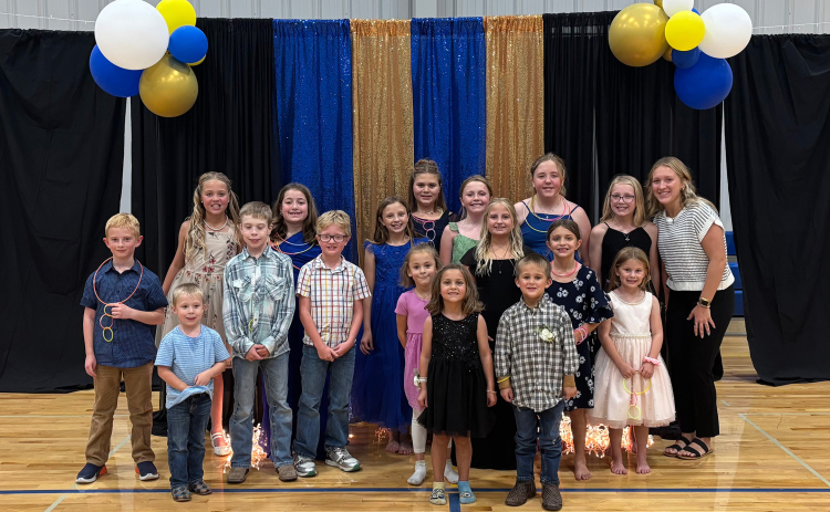 Little Spartans gather with event organizer Kendall Kolousek for a photo during the Little Spartans Homecoming Prom. Kolousek organized the event as her senior project, giving students in grades K-6 a chance to dress up, have fun and make Homecoming memories of their own. (PHOTO COURTESY LIZA KOLOUSEK)