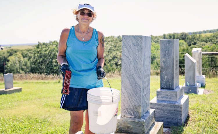 Sandy Jones carefully scrubs years of moss and lichen from a headstone at Prospect Hill Cemetery in Wessington Springs. Jones began cleaning the cemetery’s aging markers last summer and has devoted more than 40 hours to the volunteer project this year.