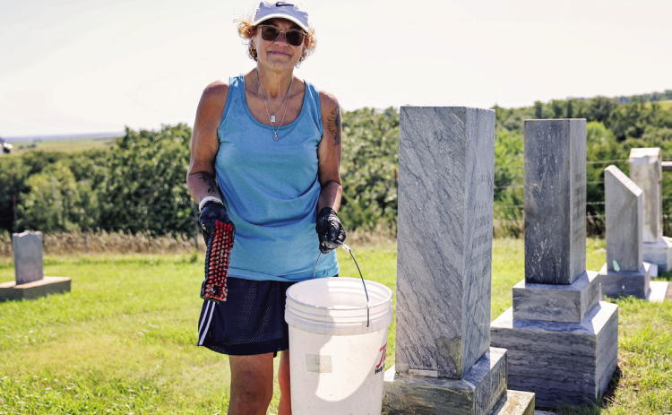 Sandy Jones carefully scrubs years of moss and lichen from a headstone at Prospect Hill Cemetery in Wessington Springs. Jones began cleaning the cemetery’s aging markers last summer and has devoted more than 40 hours to the volunteer project this year.