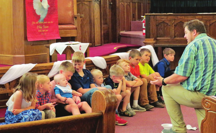 Connecting with children and young adults is seen as an important way to grow church membership in the future. Here, Methodist Pastor Zach Kingery teaches scripture to children at the United Methodist Church of Wessington Springs during a “Young Disciples Moment” in 2022. Photo: Courtesy Laura Kieser, UMC